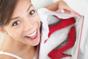 Woman getting shoes as gift. Young beautiful woman surprised and happy to receive red high heels shoes as a present or shopping. Click for more:
